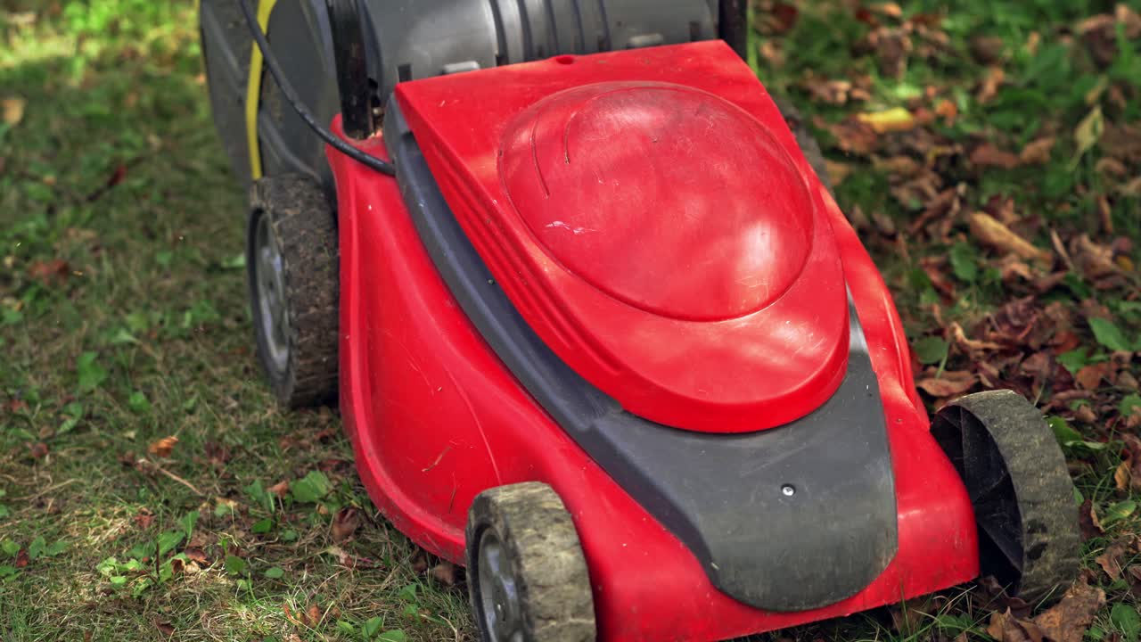 Lawn mower cutting green grass. Close up of garden meadow lawn cutting