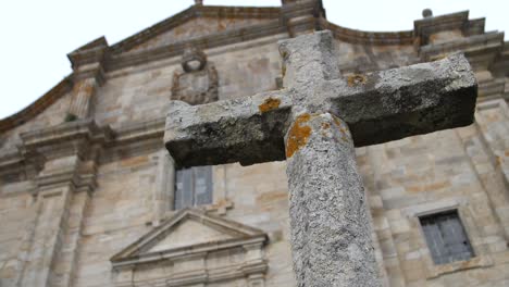 christian cross in front of the royal monastery of santa maria de oia in the portuguese way of saint james in the atlantic coast in galicia