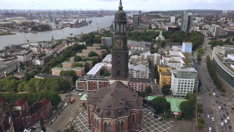 flying-towards-church-in-hamburg-city-germany,-gaining-hight,-tilting-camera-down