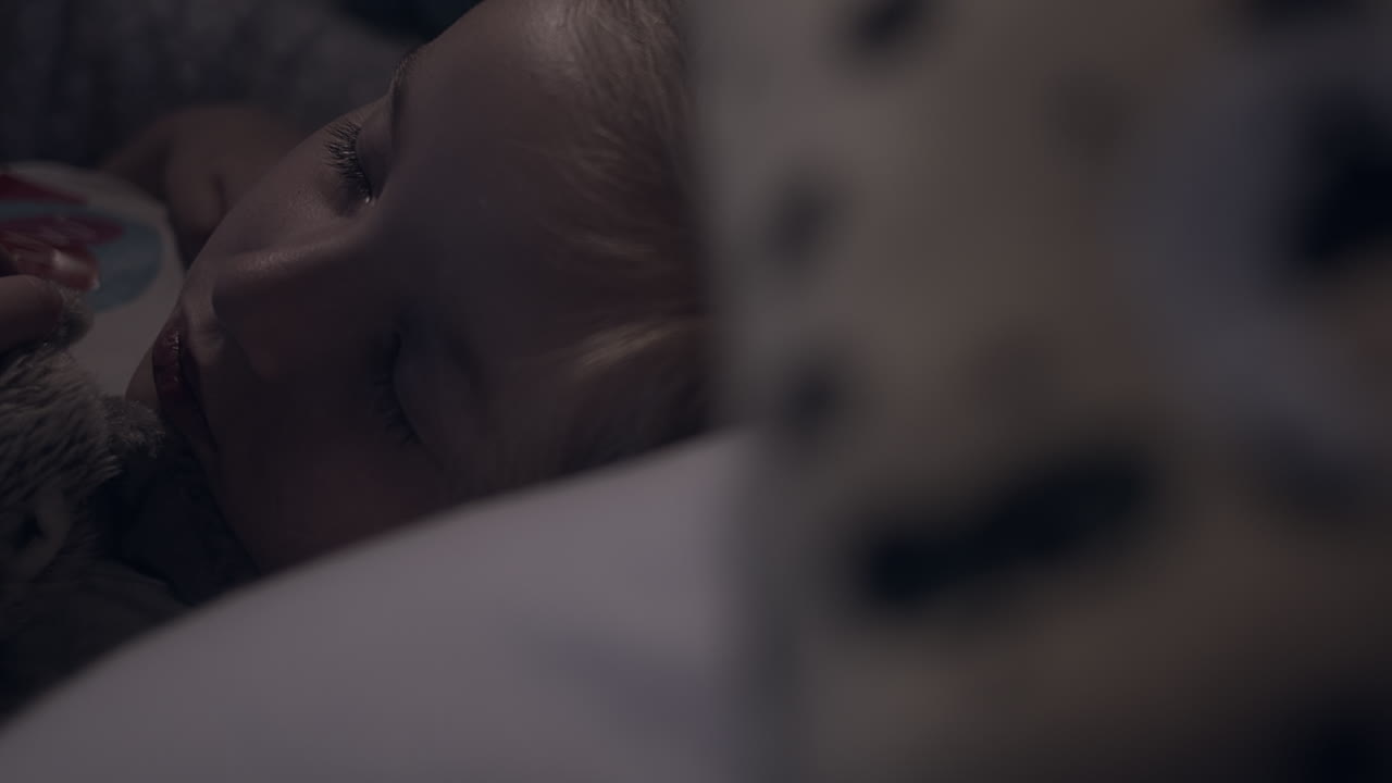 la niña duerme tranquilamente en la cama por la noche, se enfoca