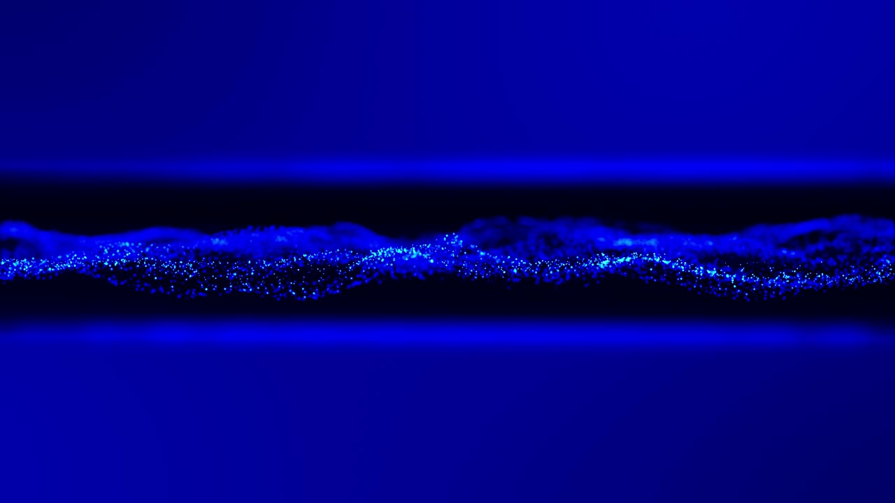 Blue waving energy particles as abstract technology design blurred background. UHD 4K seamless video loop animation.