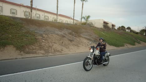 young woman on a vintage motorcycle speeds up on the road to pass