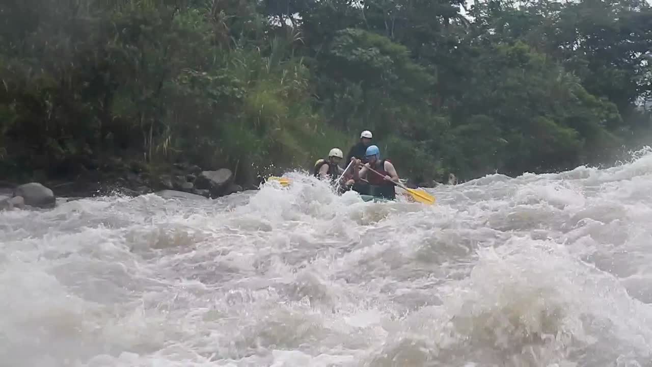 Tourists rafting in Baños, Ecuador over a strong river that is taking them forward