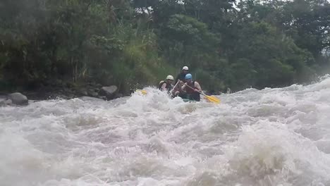 tourists rafting in baños, ecuador over a strong river that is taking them forward