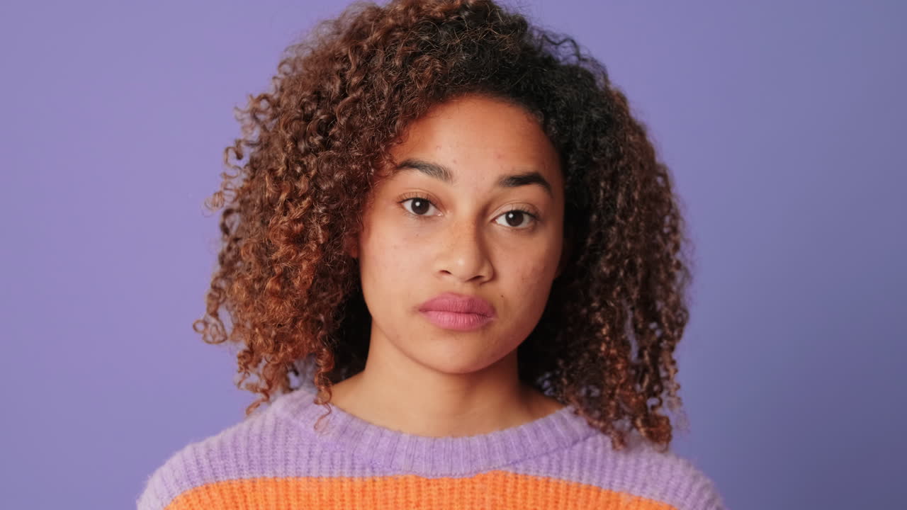 Close-up Portrait of a Serious Young Woman with Curly Hair