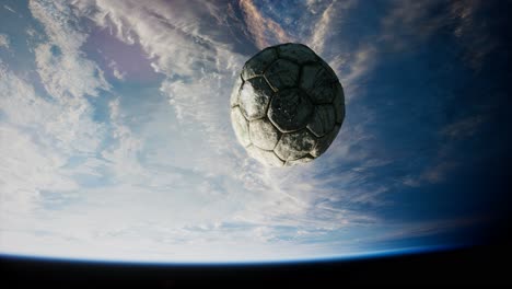 old soccer ball in space on earth orbit