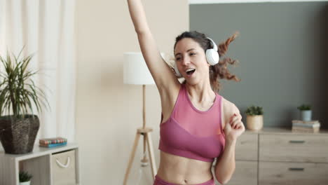 mujer caucásica deportiva bailando en casa