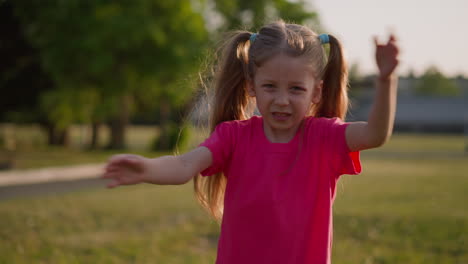 Disgusted-little-girl-waves-off-annoying-insects-on-lawn