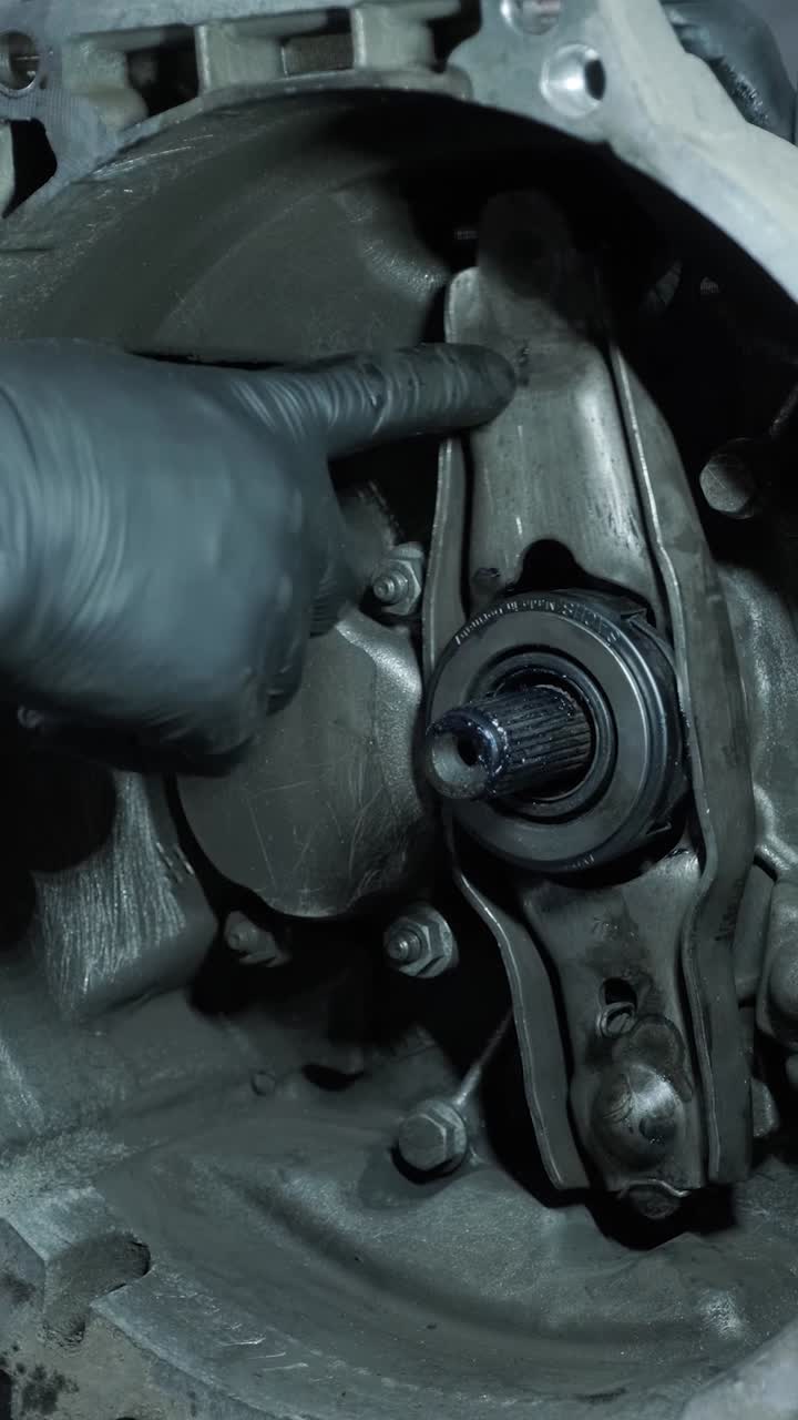 Mechanic's Hand Pointing at Car Clutch Release Bearing