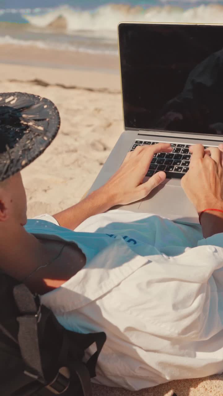 hombre trabajando en una computadora portátil en la playa