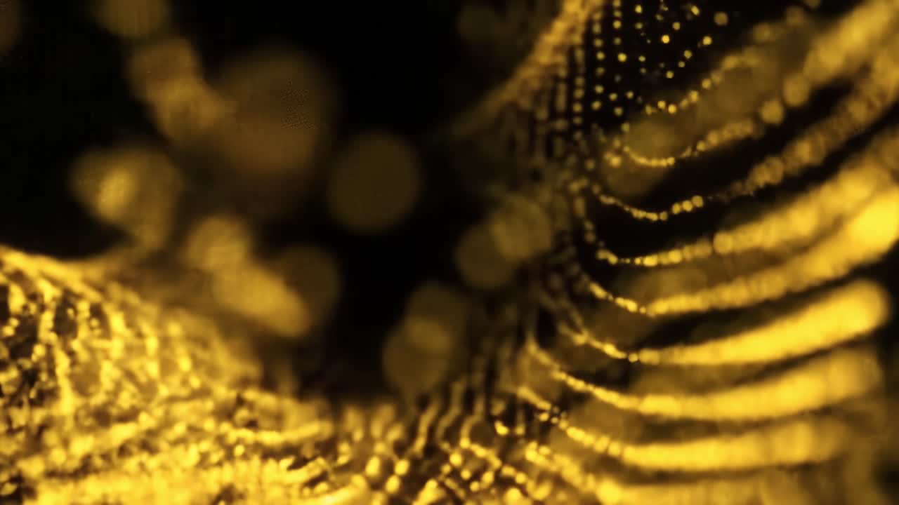 Dazzling golden light patterns flow and dance in a captivating display, captivating viewers at an evening event in the city. The enchanting visuals create an immersive atmosphere.