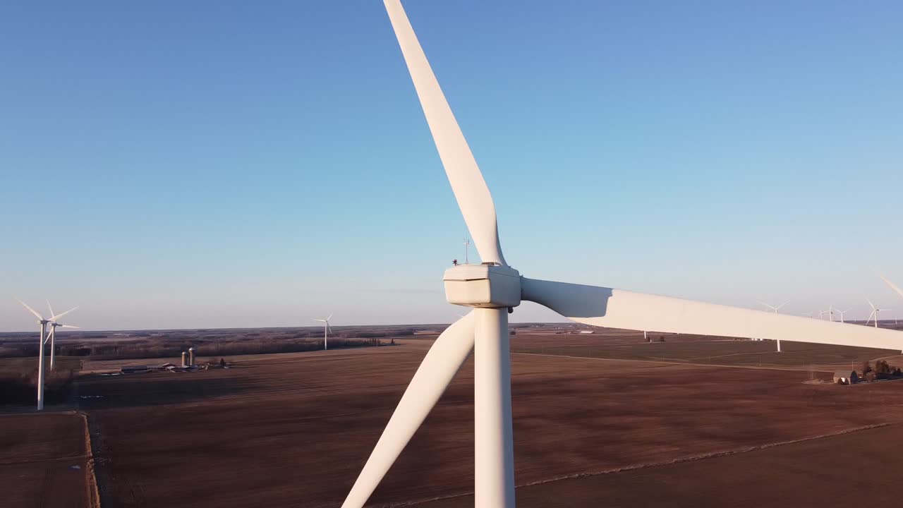 Flying behind an Ubly, Michigan windmill overlooking the wind farm - aerial