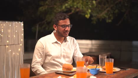 indian boy eating burger and fries smiling face junk food orange juice