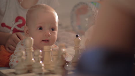 cute baby girl watching chess game