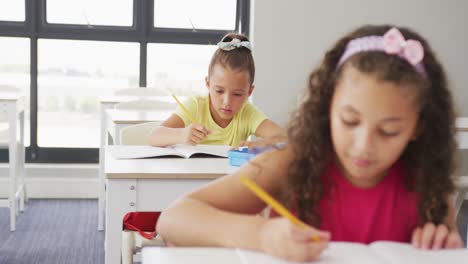 video de niñas diversas centradas sentadas en los escritorios de la escuela y aprendiendo