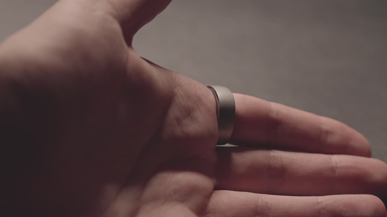 Sleek smart ring adorns the finger, blending jewelry with health tracking. It monitors vital signs, seamlessly integrating technology and style.