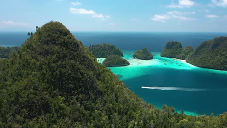 Excelente-Toma-Aérea-De-Una-Lancha-Que-Pasa-A-Toda-Velocidad-Por-Las-Islas-Wayag,-Raja-Ampat,-Indonesia