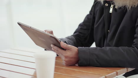 Mittlere-Aufnahme-Afroamerikanischer-Junger-Mädchenhände-In-Grauer-Jacke,-Die-Draußen-Auf-Einem-Tablet-Tippen