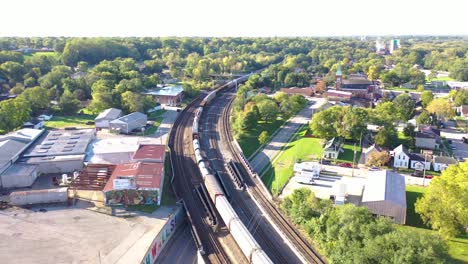 antena sobre un largo tren de carga de vagones petroleros que se mueven rápido a través del medio oeste rural