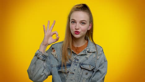 Teen-stylish-girl-looking-approvingly-at-camera-showing-ok-gesture-like-sign-positive-something-good