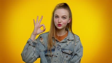 chica adolescente elegante mirando con aprobación a la cámara mostrando ok gesto como señal positivo algo bueno