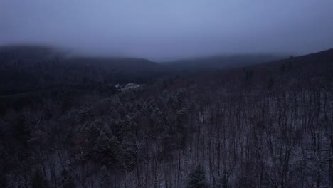 aerial drone video footage of a beautiful snowy, foggy evening with low clouds in the appalachian mountains during winter