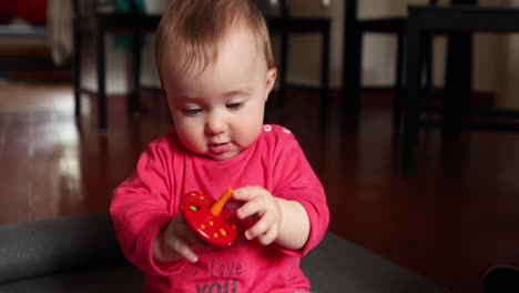 cute little baby plays in front of the camera with a wood toy, shot in slow motion-1