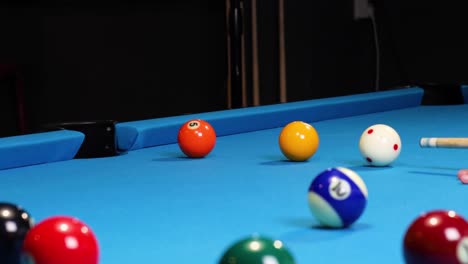 hitting yellow and orange ball in a game of pool billiards