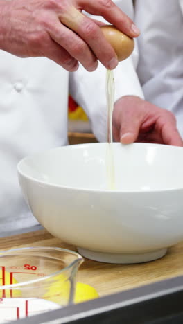 chef rompiendo un huevo en un cuenco
