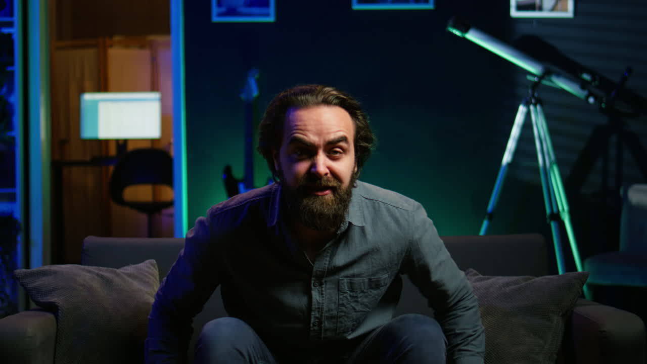 hombre loco lanzando almohada en frustración, maldiciendo a su propio equipo por ser derrotado