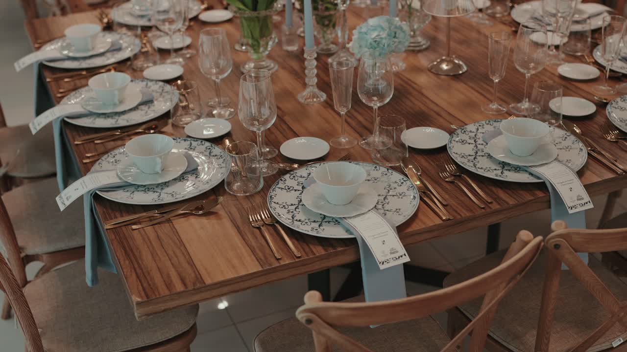 Beautifully arranged table with floral plates, glasses, and gold cutlery