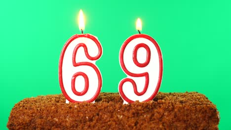 cake with the number 69 lighted candle. chroma key. green screen. isolated