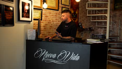 entrepreneur tattooist checking agenda at the computer the reception of his studio