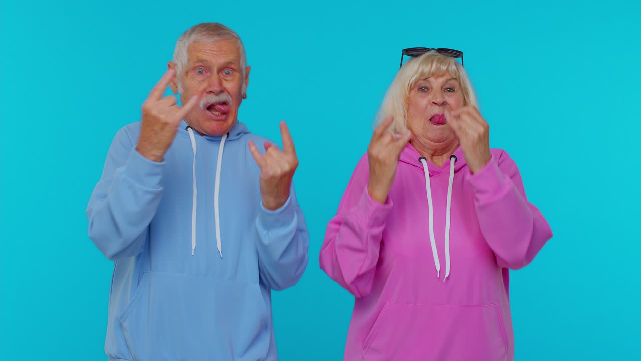 웃는 할머니, 할아버지, 손으로 록 앤 롤 제스처를 보여주는 미치광이 성공 춤