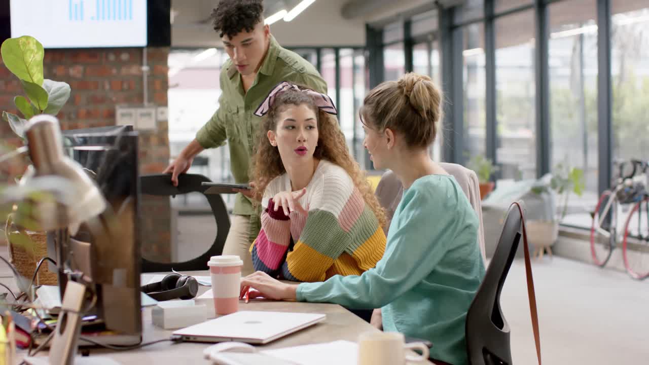 Busy diverse business people working on computer and talking in slow motion