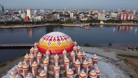 aerial view of the iconic 99 domes mosque in makassar with city skyline and waterfront