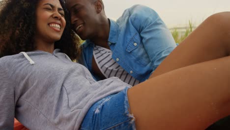 Front-view-of-African-american-couple-interacting-each-other-on-the-beach-4k