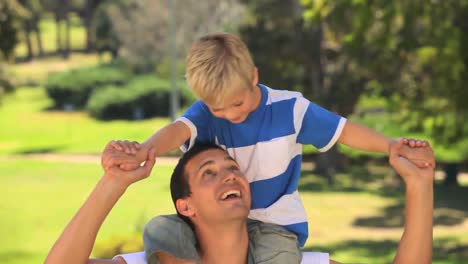 Young-boy-sitting-on-his-fathers-shoulders