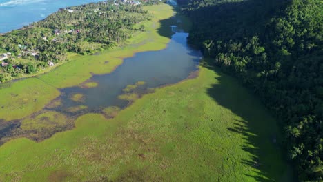 picturesque view of tropical island valley with mangrove swamp waters and lush hills at catanduanes, philippines - aerial tilt-up reveal