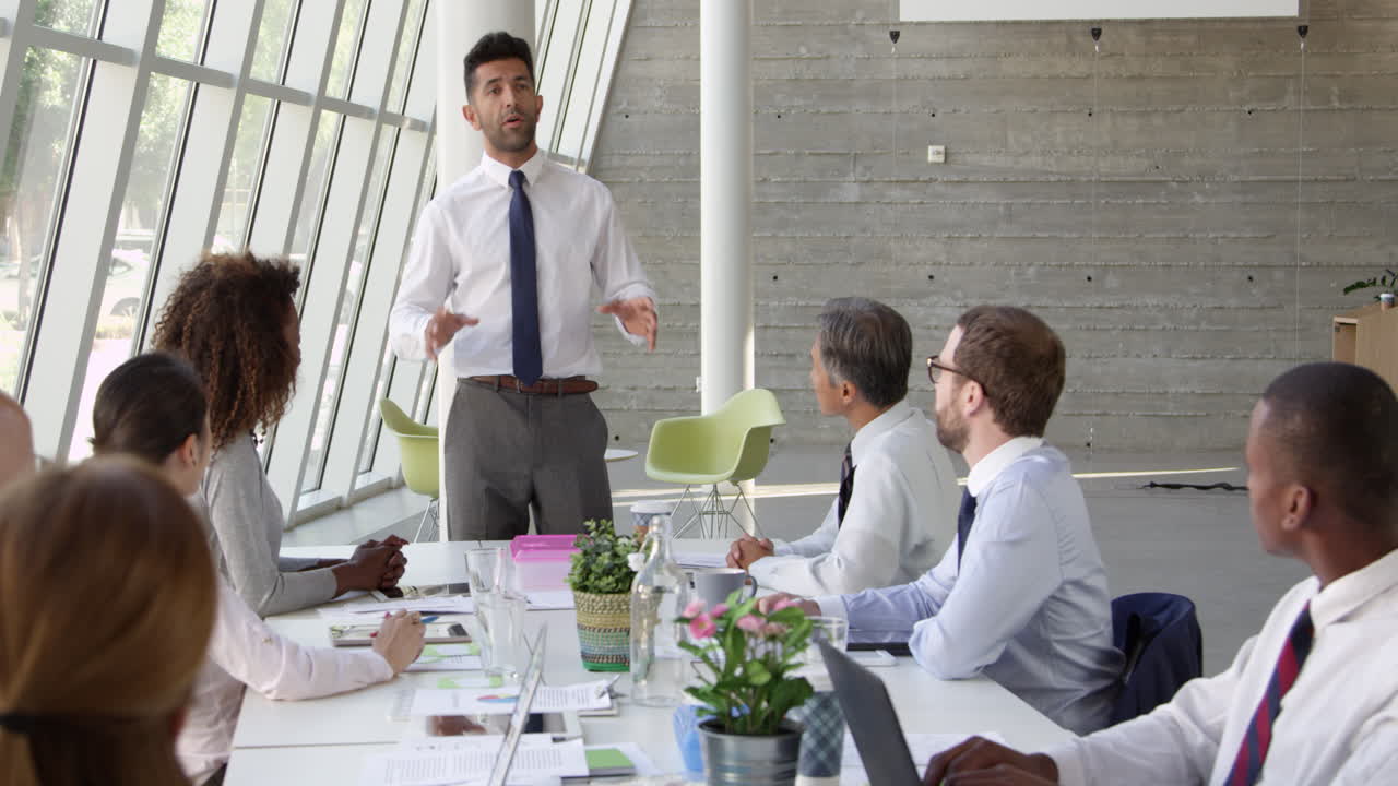 hombre de negocios liderando una reunión en la mesa de la sala de juntas filmado en r3d