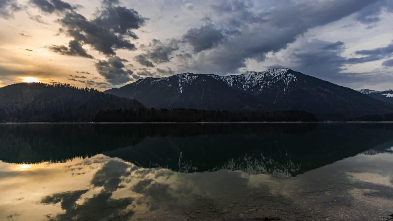 la luz del sol dorada se eleva mientras las nubes se mueven muy rápido sobre los alpes alemanes