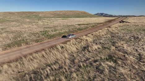 imagen de avión no tripulado de un coche conduciendo en un camino de tierra en willcox, arizona, rastreo de disparo aéreo avión no pilotado se mueve detrás del coche