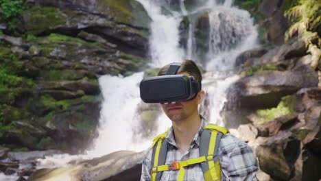 a person in a virtual reality helmet against the backdrop of a beautiful waterfall