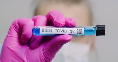 researcher holding covid 19 sample tube in hand 3