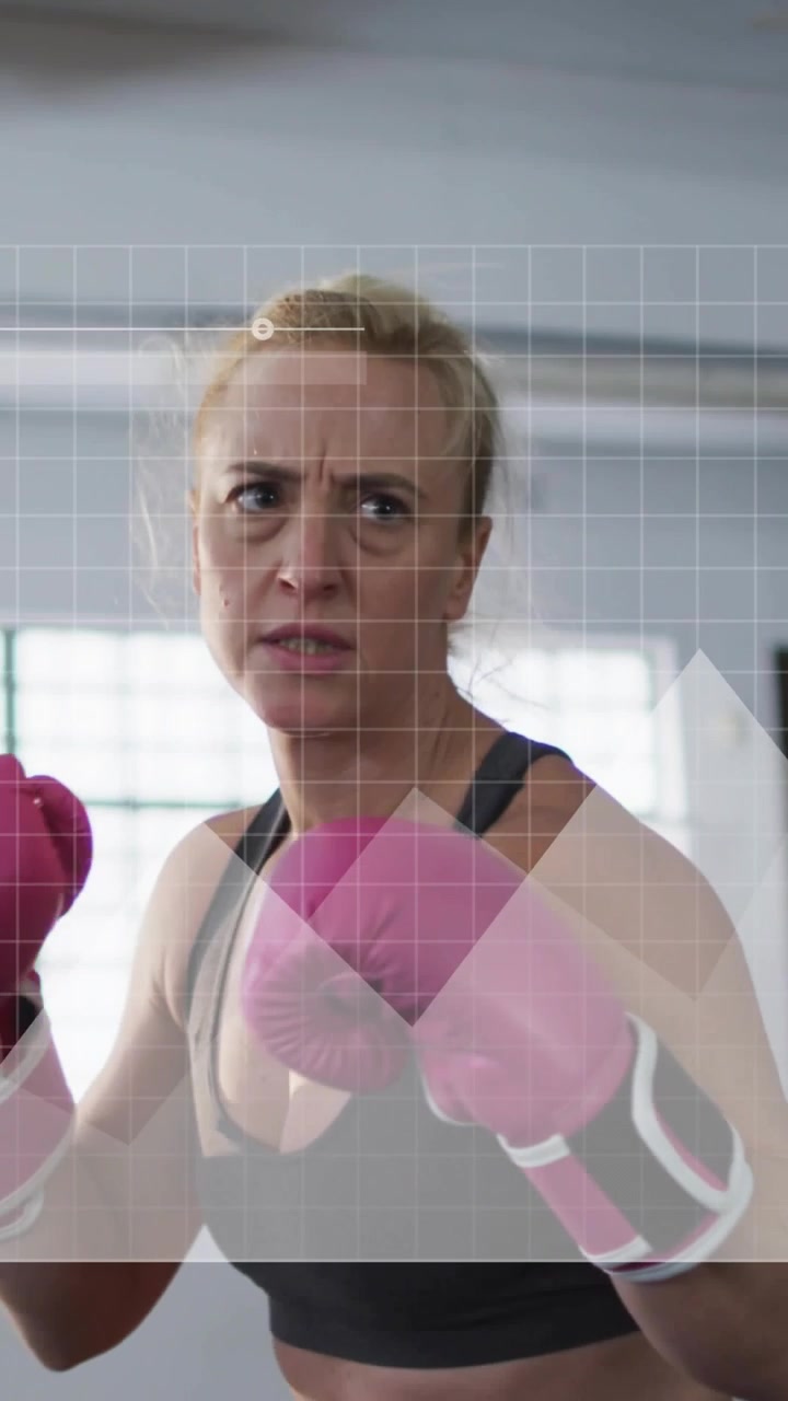 Video vertical: Boxeador levantando guantes rosas, lanzando jabs y rodillazos, con una superposición de cuadrícula de seguimiento de fitness.