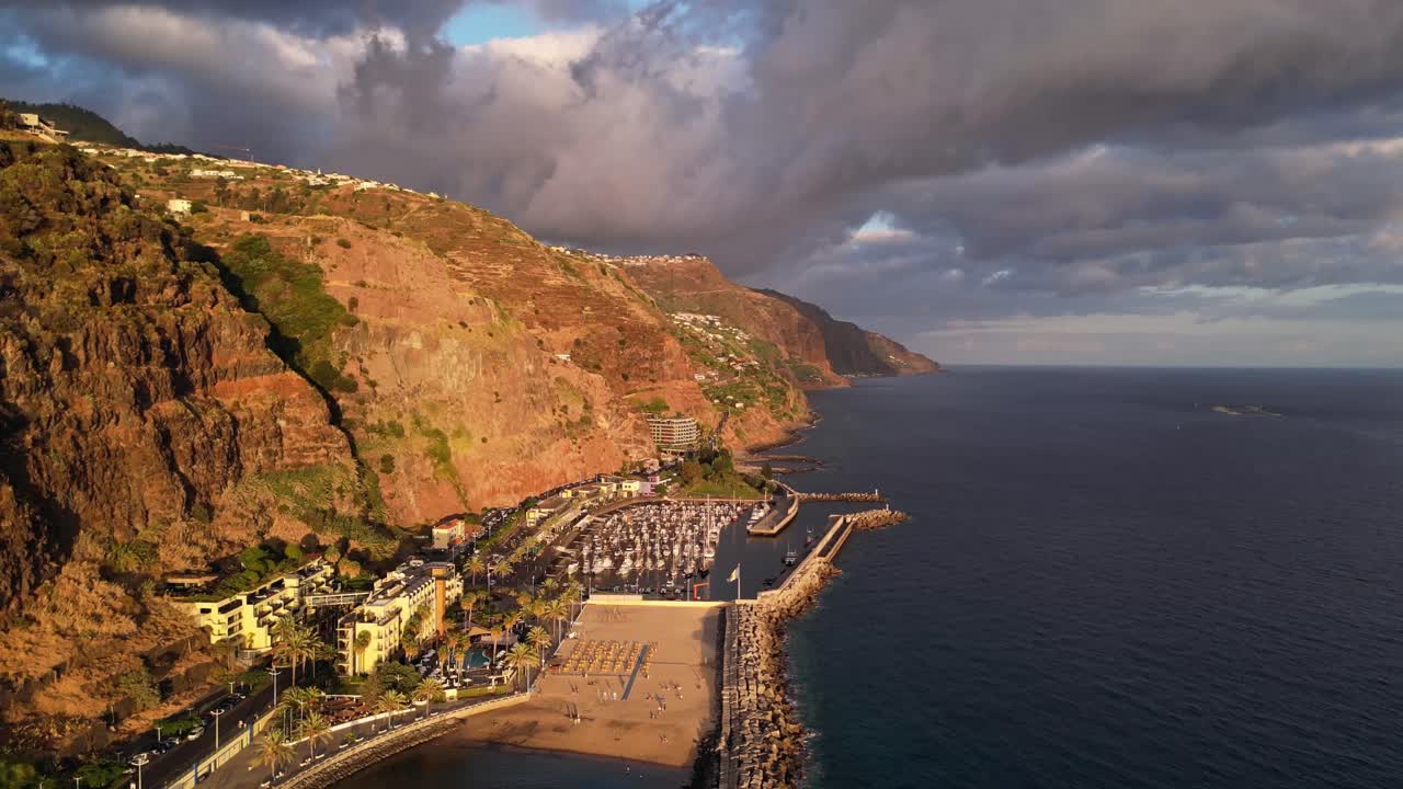 Stunning aerial view of Calheta beach and marina in Madeira, Portugal during sunset.