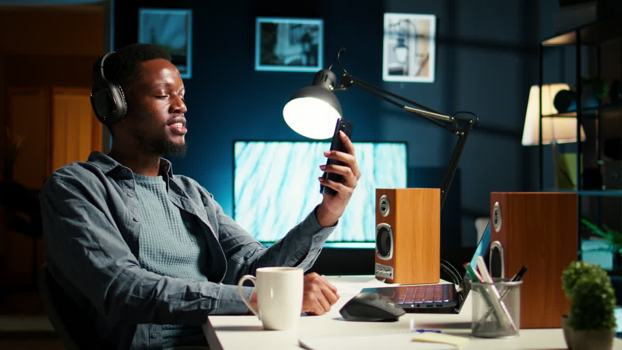 African american man waving and attending a web meeting