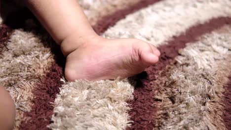 child checking their feet on a carpet