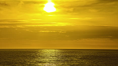 Vista-Del-Sol-Saliendo-Por-Detrás-De-Las-Nubes-Blancas-En-Un-Lapso-De-Tiempo-Sobre-El-Agua-Del-Mar-A-Lo-Largo-De-La-Costa-En-Via-Molino,-Italia-Al-Amanecer