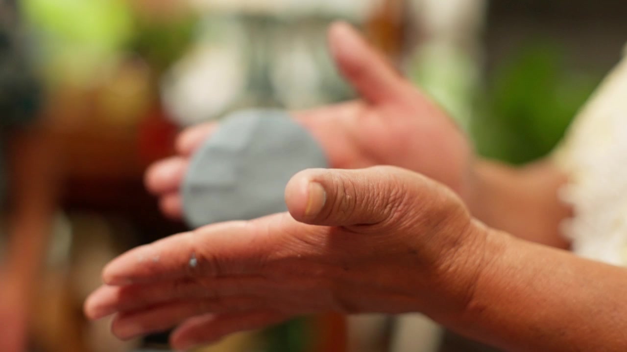 Hands gently forming and molding soft green tortillas, wrapping and forming with fingers and palms during traditional food making workshop, tossing and shaping